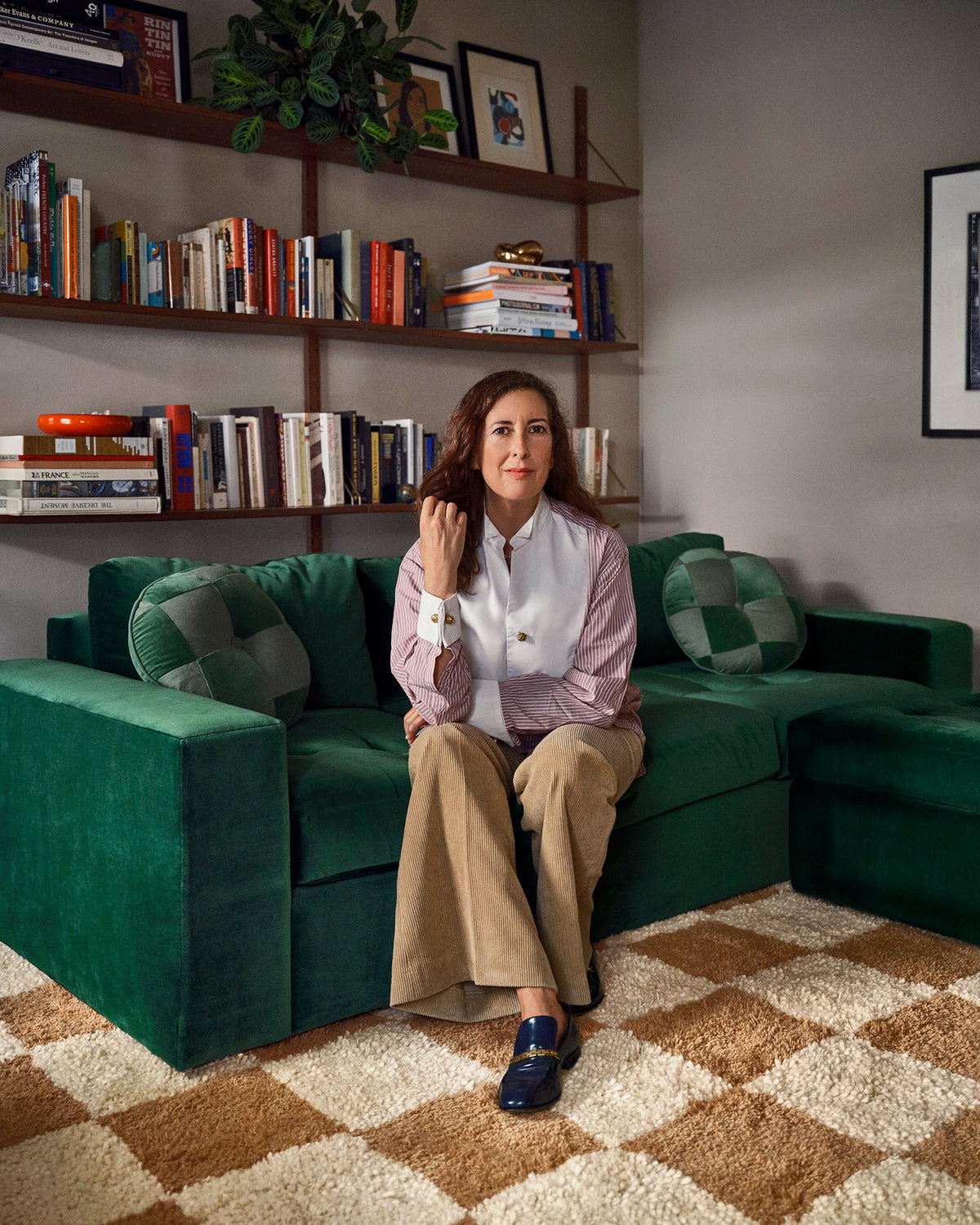 Clare sitting on the green CV x Schoolhouse sofa.