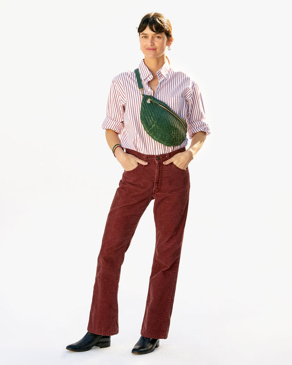 Danica wearing the Evergreen Woven Zig-Zag Grande Fanny across her chest in maroon pants and  a button down shirt