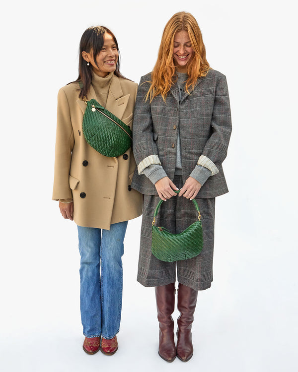 Maly wearing the Evergreen Woven Zig-Zag Grande Fanny across her chest. Haley standing beside her wearing the Evergreen Woven Zig-Zag Petit Moyen