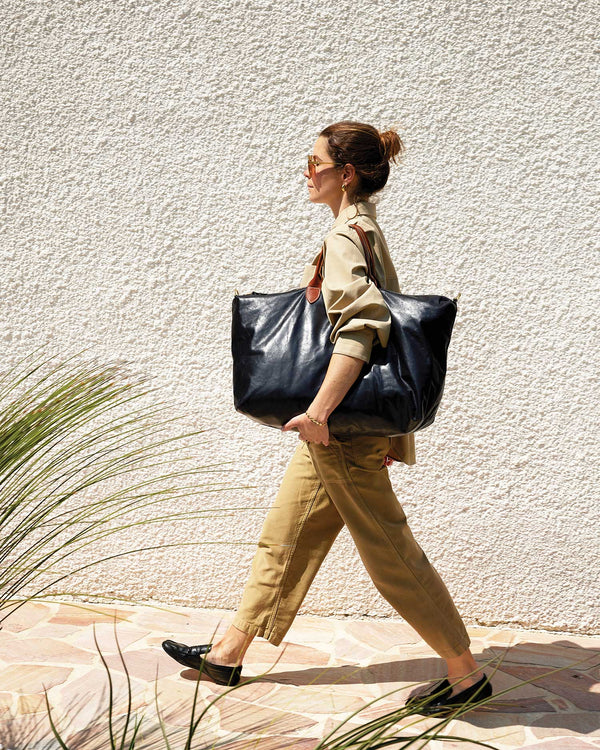 Model is walking and carrying the black weekender on her shoulder