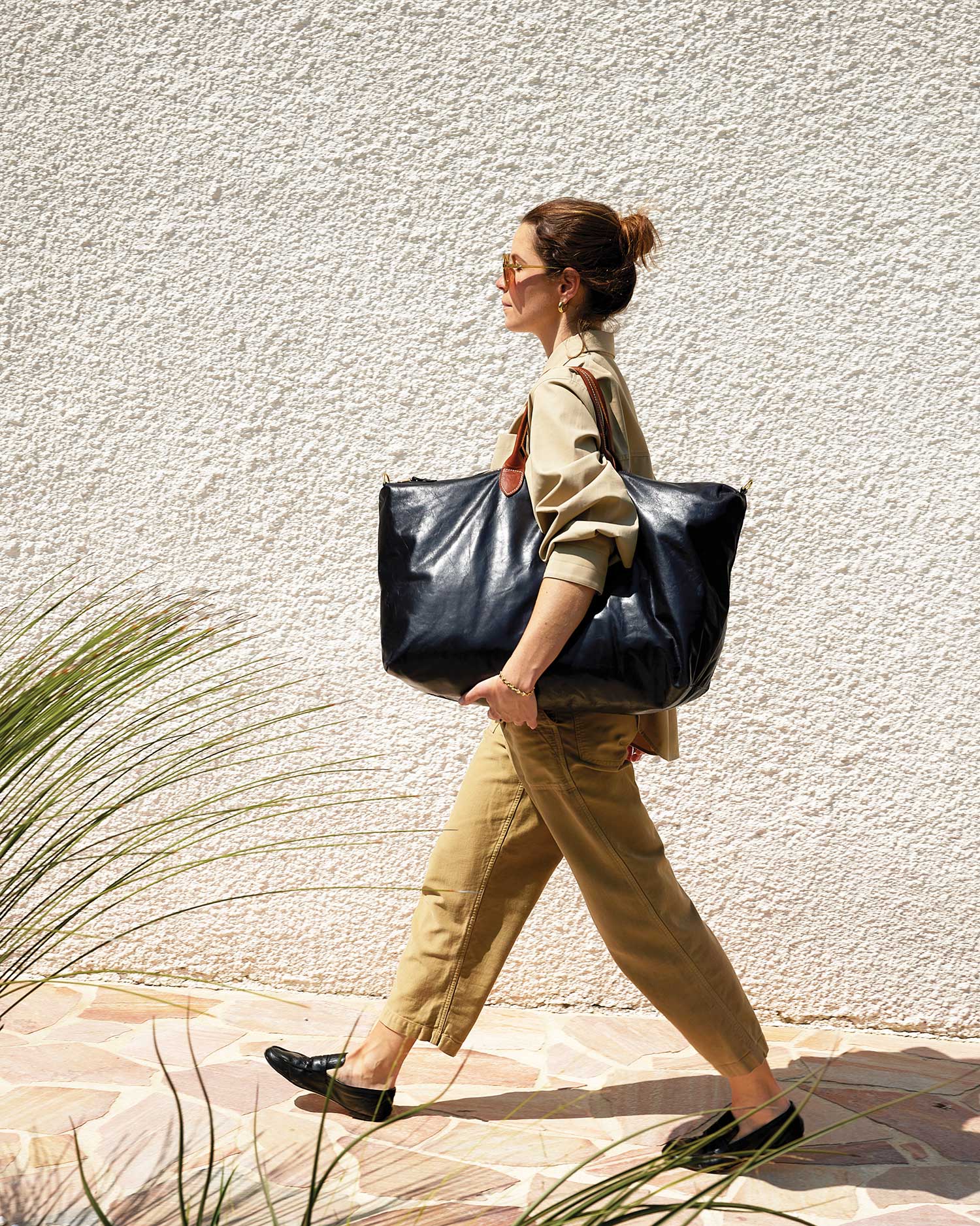 Model is walking and carrying the black weekender on her shoulder