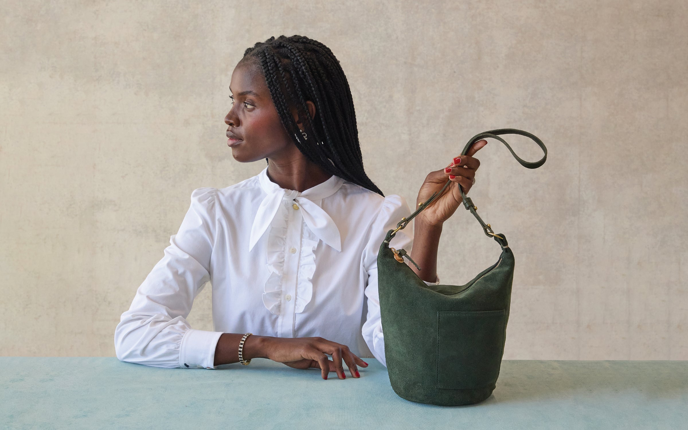 Model holding the Loden Suede Petite Jeanne.