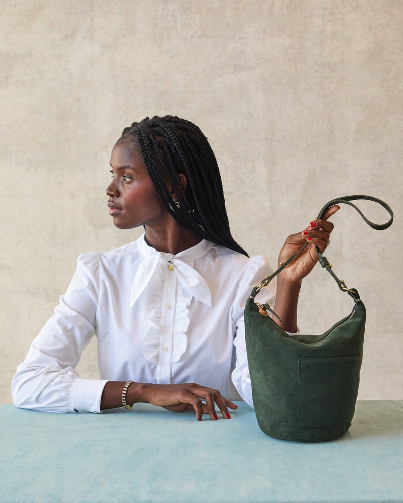 Model holding the Loden Suede Petite Jeanne.