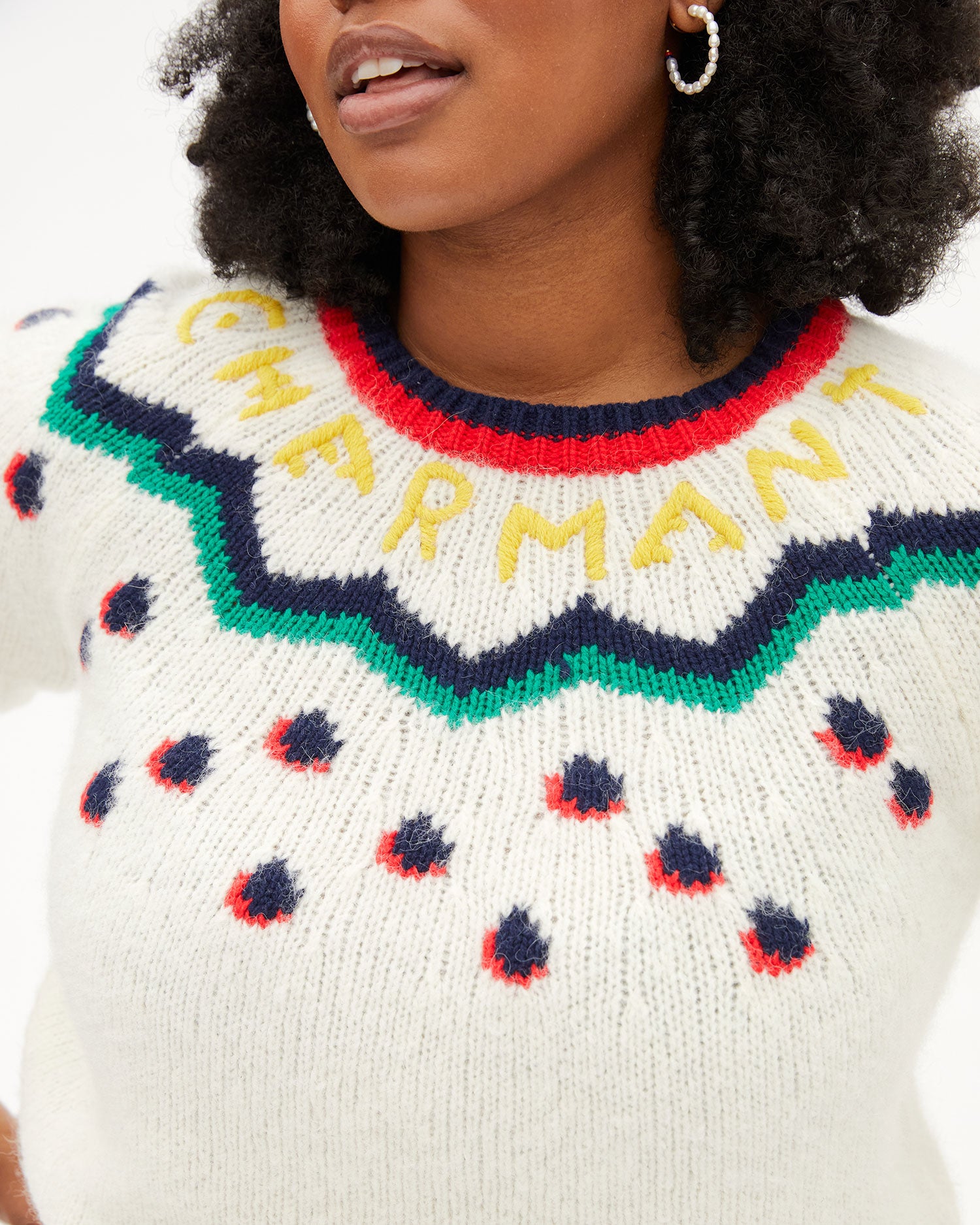 close up of the yellow Charmant lettering on the Cream Multi Fair Isle Ragland Sweater worn by Candace